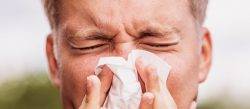 Man blows nose into tissue